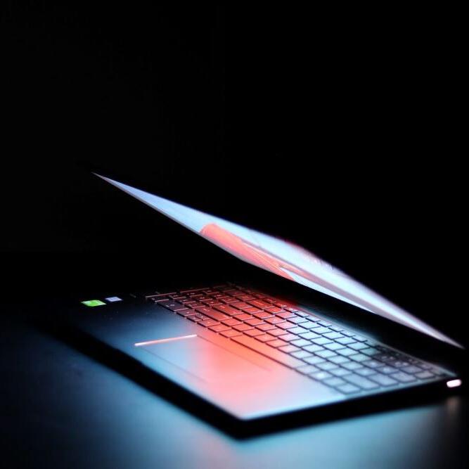 A Lenovo computer with a bright display on a dark background.